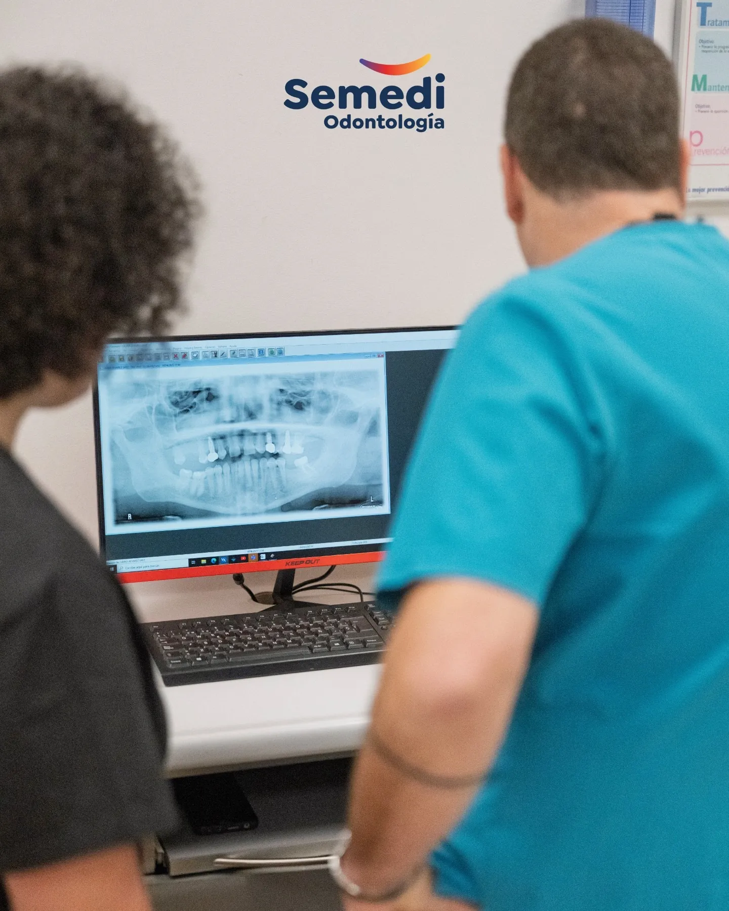 Dentista en Málaga revisando una radiografía panorámica dental en pantalla junto a la paciente en Semedi Odontología